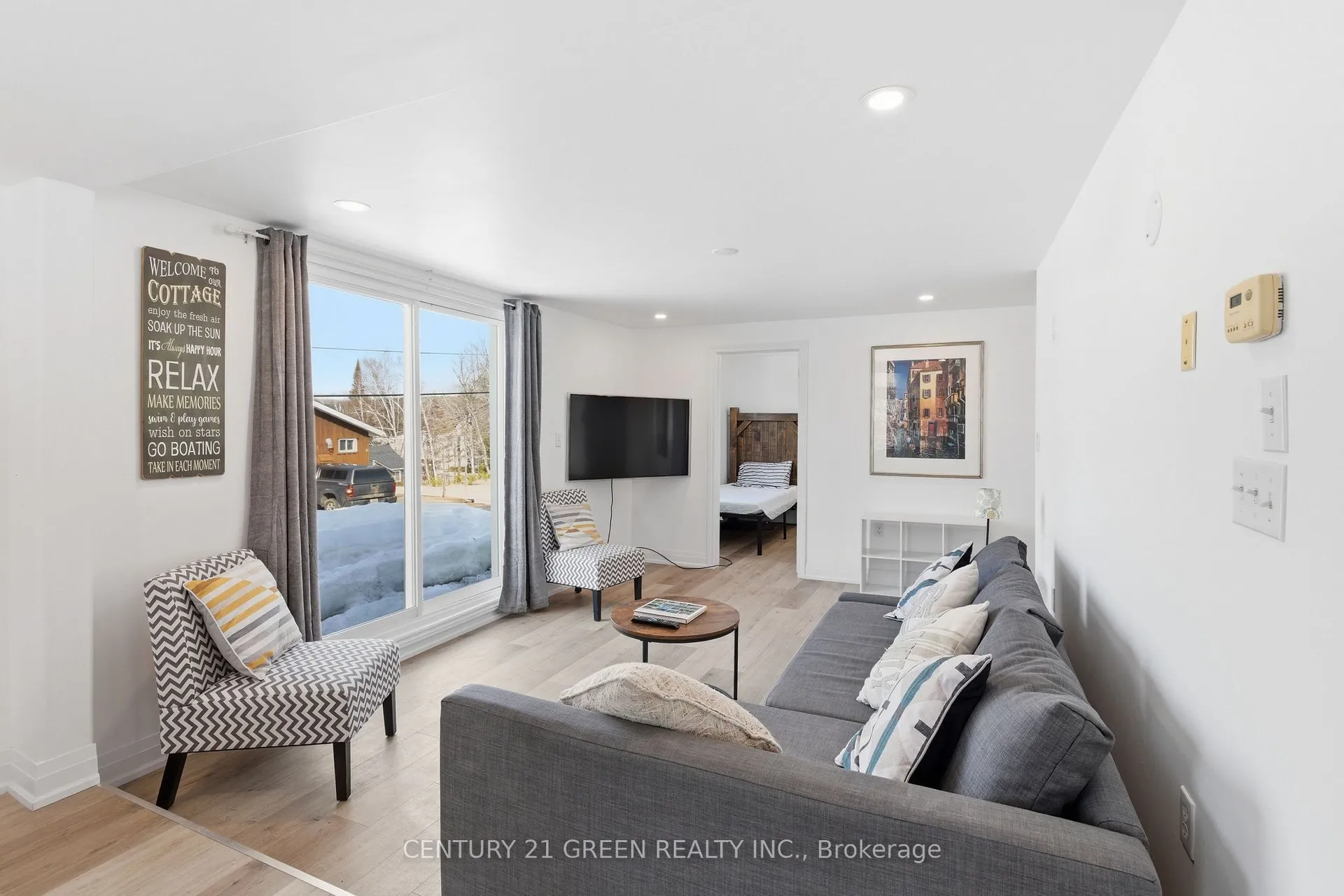 135 Village Street, Hastings Highlands — living room with sofa, television, patio door and bedroom doorway